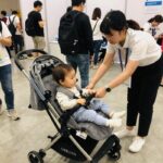 수원 코베 베이비페어에서 부모가 유모차를 직접 체험해보는 모습