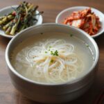 풍년비빔국수 비빔국수 그릇과 열무김치 접시가 함께 있는 모습