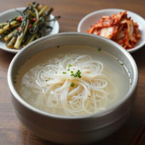 풍년비빔국수 비빔국수 그릇과 열무김치 접시가 함께 있는 모습
