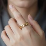 수지가 착용한 셀린느 노트 반지의 은은한 매듭 디테일과 골드 컬러를 클로즈업한 사진