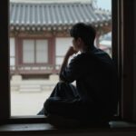 창가에 앉아 멀리 바라보며 생각에 잠긴 사람의 실루엣, 사색적 순간을 상징하는 이미지