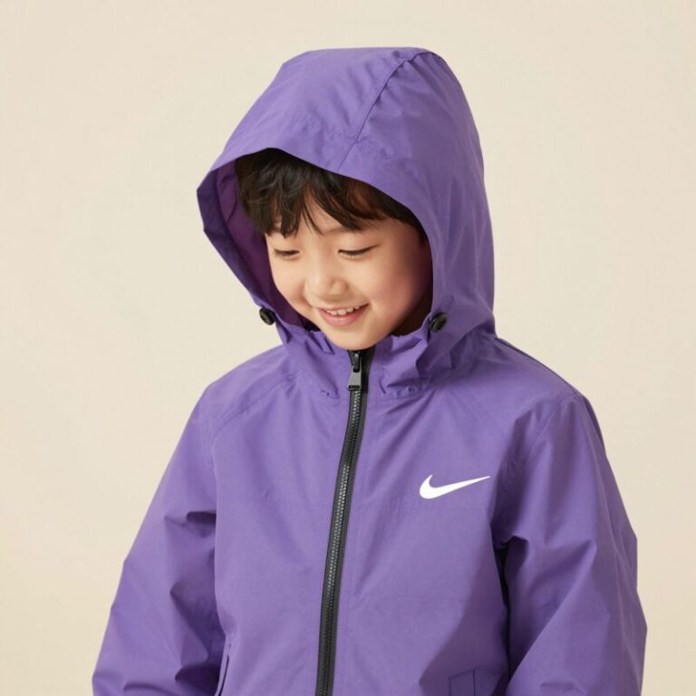 라벤더 컬러의 나이키 키즈 스우시 윈드러너 바람막이를 입은 아이가 밝은 배경에서 웃고 있음