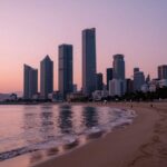 해운대해수욕장 2026 완벽 즐기기 해운대 해변에서 바라본 일몰 풍경, 핑크빛 하늘과 고층 빌딩이 어우러진 모습
