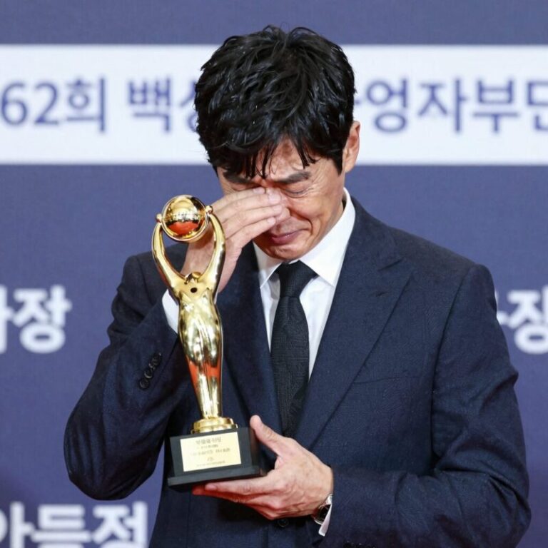 유해진이 제62회 백상예술대상 영화부문 대상 트로피를 들어 보이며 감격스러운 표정을 짓고 있다