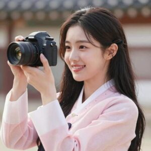 권은빈이 2026년 화보에서 카메라를 바라보며 미소 짓고 있는 모습. 부드러운 핑크 톤 의상이 돋보인다.