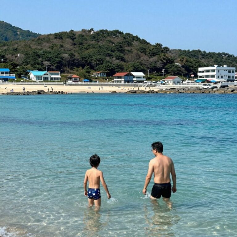 금능해수욕장에서 아들과 함께 물놀이하는 모습 에메랄드빛 바다와 야자수가 배경