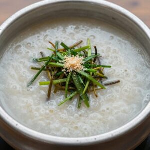 차가운 육수에 살얼음이 동동 떠 있는 냉모밀 그릇, 위에 갈은 무와 쪽파, 김가루, 와사비가 올려져 있다.