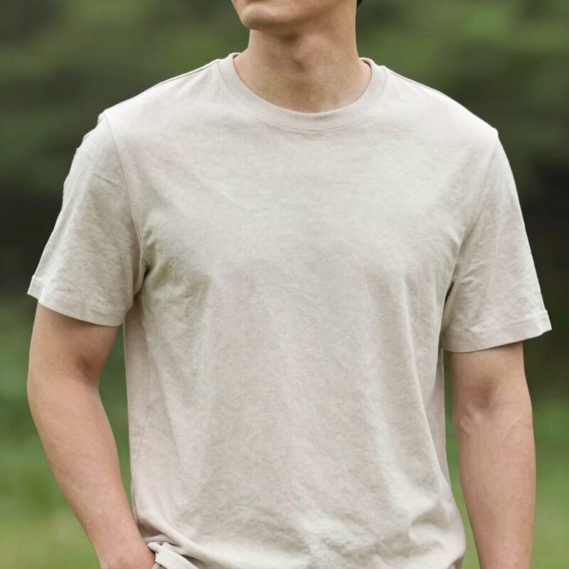 시원한 남자 여름 면바지 고르기 1 밝은 베이지색 남자 여름 면바지와 흰색 티셔츠를 입은 남성이 야외에서 자연스럽게 포즈를 취한 모습