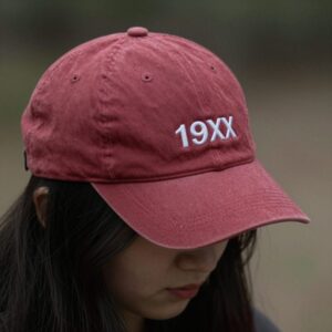 비헤비어 19XX 로프 트러커 캡을 옆에서 찍은 사진. 깊은 챙과 빈티지 레드 컬러가 두드러진다.