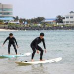 제주도 월정리 해변에서 강사와 함께 서핑 강습을 받는 모습
