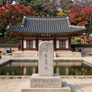 용인 와우정사 입구 불두상과 연못, 뒤로 단풍나무가 보이는 풍경