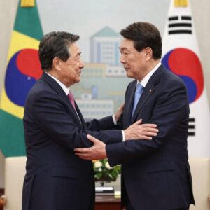 이재명 대통령과 룰라 브라질 대통령이 정상회담장에서 포옹하며 인사하고 있는 모습, 배경에는 브라질 국기와 한국 국기가 보인다