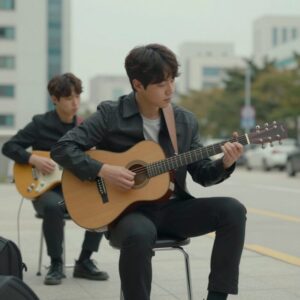 글렌 핸사드가 영화 원스에서 기타를 연주하는 모습, 아카데미 시상식에서 Falling Slowly로 주제가상을 수상한 장면