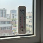 아기방 에어컨 온도 제대로 맞추는 법 아기방 온도계와 에어컨 리모컨, 단열필름이 부착된 창문