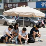 폭염중대경보 확대 대비 생활 수칙 폭염 경보 속 그늘에서 휴식하는 시민들의 모습. 그늘막 아래 앉아 물을 마시고 있는 사람들.