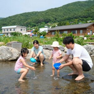 성주 포천계곡 펜션 평상에서 물놀이하는 가족 모습
