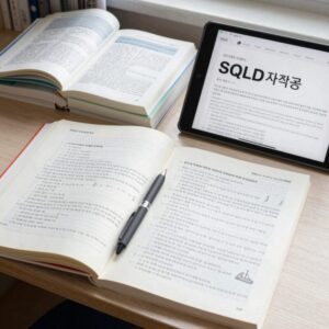 SQLD 자격증 공부를 위해 책상 위에 펼쳐진 교재와 노트, 태블릿으로 PDF를 보는 모습