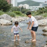 탑텐키즈래쉬가드 여름 물놀이옷 준비 끝 아이가 탑텐키즈 메쉬 레이어드 T와 타슬란 쇼츠를 입고 계곡에서 즐겁게 물장구치는 모습